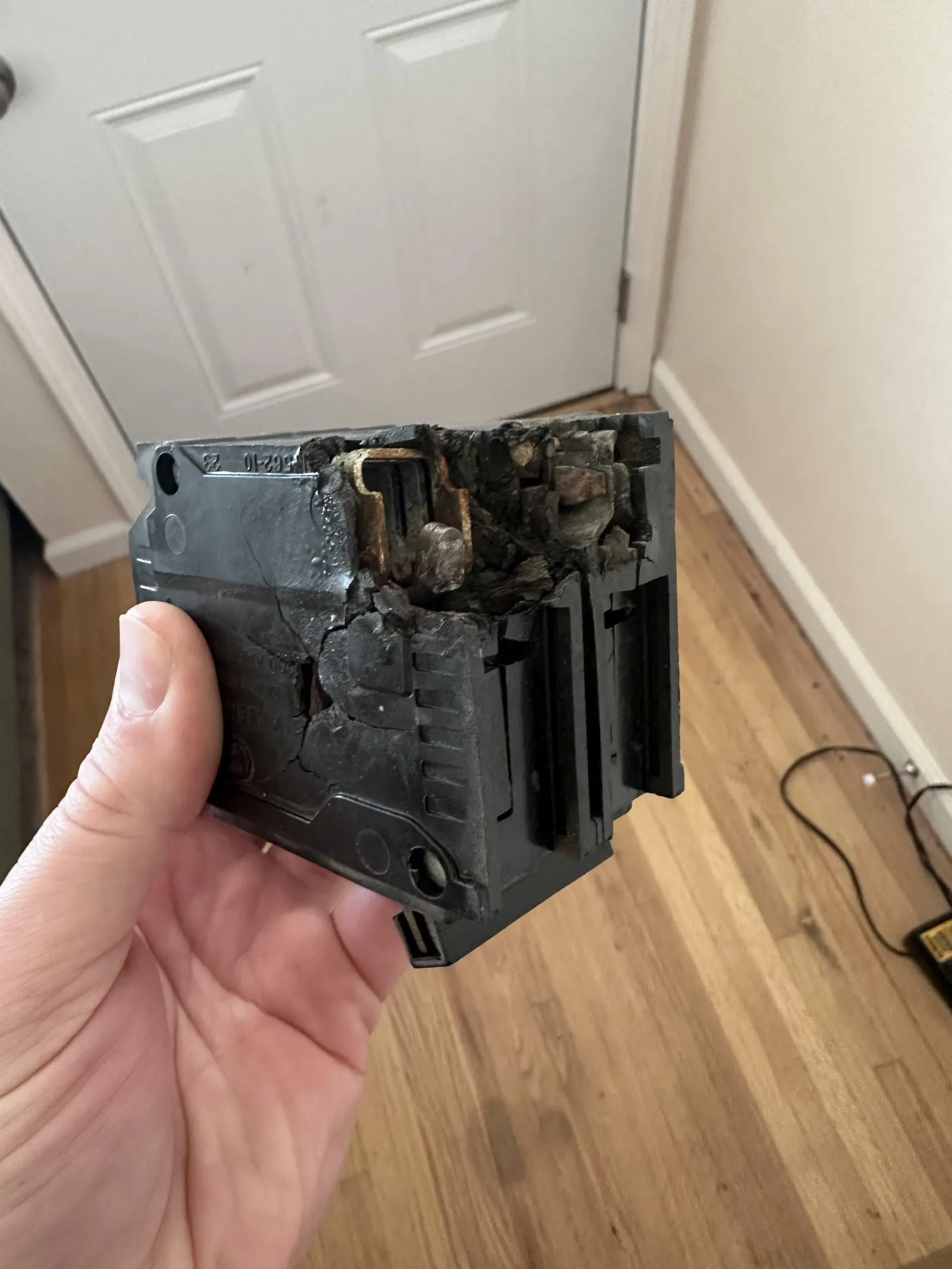 Burned circuit breaker removed from a Marietta electrical panel, with heat damage at the bus-bar clip