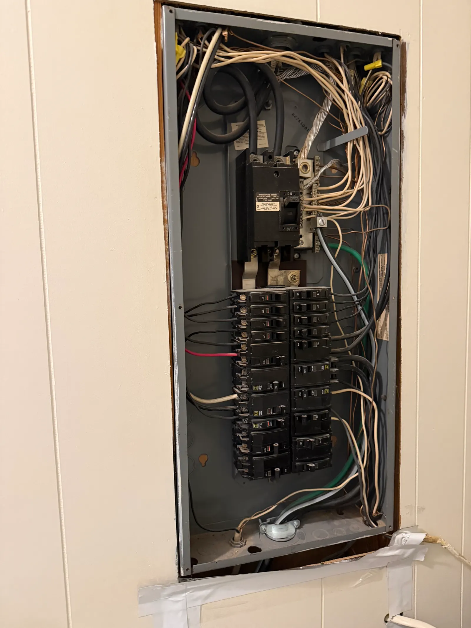 Older uncovered electrical panel in a Marietta home with exposed bus and breakers